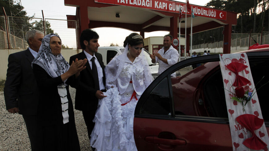 Syrian bride Reme and her Turkish groom Rasim Yuce leave the Turkish side of the Yayladagi border gate between Turkey and Syria in Hatay province for their wedding, after Reme's arrival from Syria, June 25, 2011. Reme, a 22-year-old hairdresser from Burj Islam, a Syrian village in Latakia province, has to cross the border for her wedding ceremony with 26-year-old driver Rasim Yuce from Aslanyazi, a Turkish village in Hatay Province. The couple met and fell in love during one of Yuce's business trips to Syri