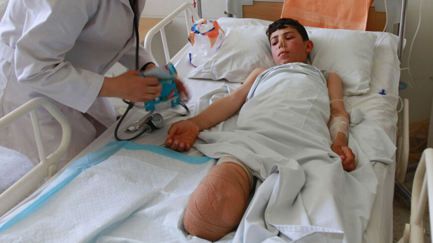Ahmad Sadek, a 13-year-old Syrian boy, receives medical treatment from a nurse in a government hospital in Tripoli, North Lebanon June 4, 2012. According to hospital officials, Ahmad was wounded four days ago during shelling by government forces in the town of Qusair in Syria. REUTERS/Omar Ibrahim     (LEBANON - Tags: CIVIL UNREST POLITICS) - RTR332UZ