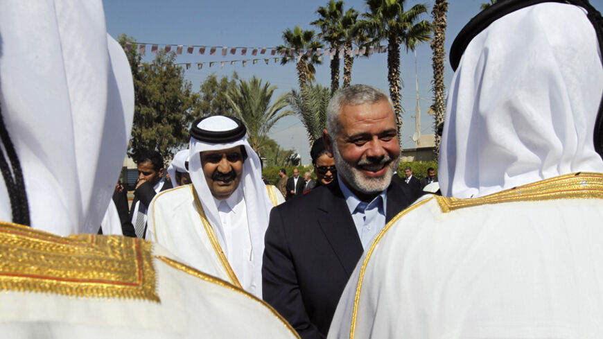 Hamas Prime Minister Ismail Haniyeh (center, R) walks with The Emir of Qatar Sheik Hamad bin Khalifa al-Thani (center, L) during a welcoming ceremony at the Rafah border crossing with Egypt in the southern Gaza Strip October 23, 2012. The Emir of Qatar embraced the Hamas leadership of Gaza on Tuesday with an official visit that broke the isolation of the Palestinian Islamist movement, to the dismay of Israel and rival, Western-backed Palestinian leaders. REUTERS/Mohammed Abed/Pool (GAZA - Tags: POLITICS) - 