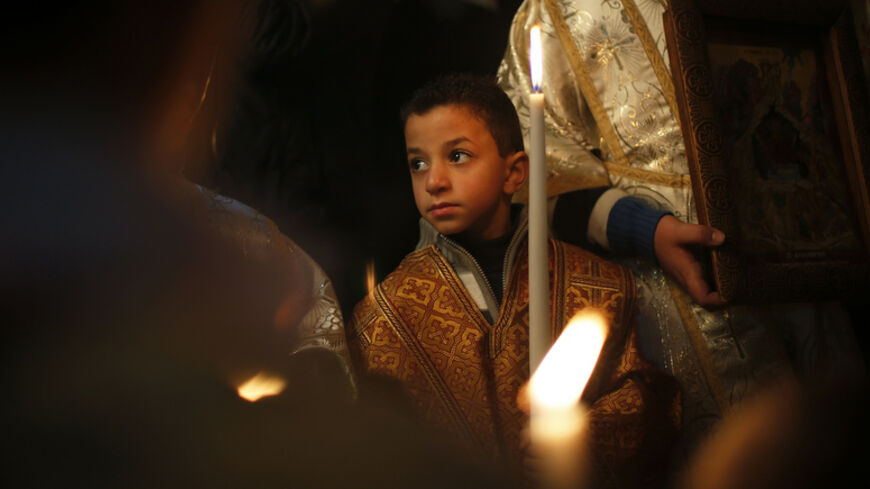 A Palestinian Greek Orthodox boy attends Christmas services at the Saint Porfirios church in Gaza City January 7, 2013. REUTERS/Suhaib Salem (GAZA - Tags: RELIGION SOCIETY) - RTR3C6CI