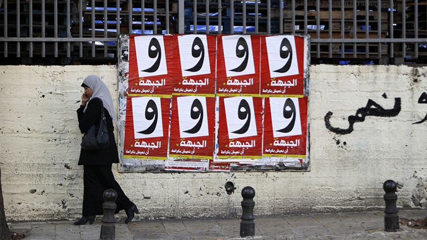A woman walks past campaign posters for the Arab-led Hadash party in the Israeli-Arab city of Umm al-Fahm December 26, 2012. Disillusioned, disappointed and divided, Israeli Arab voters will traipse to the polls next week in ever dwindling numbers, aware that none of their community will have any say in how the country is run. Picture taken December 26, 2012. REUTERS/Ammar Awad (ISRAEL - Tags: POLITICS ELECTIONS) - RTR3CHRM
