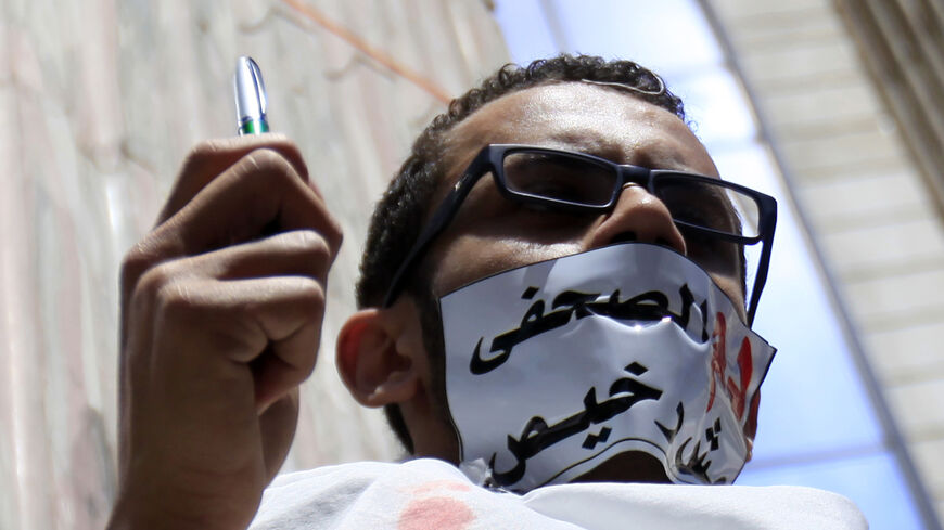 A journalist with his mouth taped holds a pen during a protest against the Interior Ministry in front of the Press Syndicate in Cairo April 17, 2014. Protesters accused the ministry on Thursday of deliberately targeting journalists during their coverage of violence and conflict. The tape reads, "The blood of a journalist is not cheap." REUTERS/Amr Abdallah Dalsh (EGYPT - Tags: POLITICS CIVIL UNREST MEDIA) - RTR3LOW1