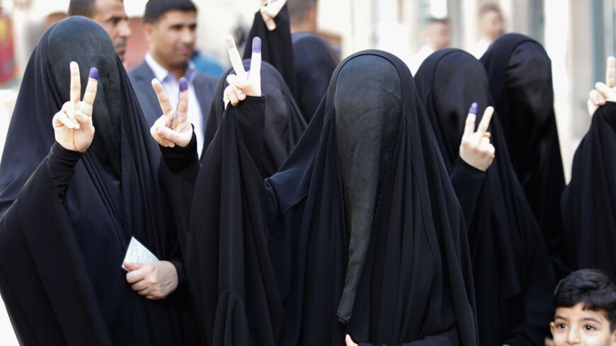 Fully-veiled women gesture with their ink-stained fingers after casting their vote during voting for Iraqi parliamentary election in Baghdad April 30, 2014. Iraqis headed to the polls on Wednesday in their first national election since U.S. forces withdrew from Iraq in 2011, with Prime Minister Nuri al-Maliki seeking a third term amid rising violence. REUTERS/Thaier Al-Sudani (IRAQ - Tags: ELECTIONS POLITICS) - RTR3N6WF