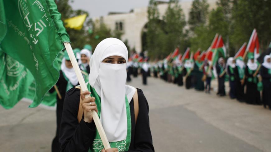 A Palestinian student supporting the Hamas movement holds a Hamas flag as she takes part in an election campaign for the student council at the Birzeit University in the West Bank city of Ramallah  May 6, 2014. 
The political parties are competing for the student council's 51 seats in an election that will take place on Wednesday.
  REUTERS/Mohamad Torokman (WEST BANK - Tags: POLITICS EDUCATION) - RTR3O04M
