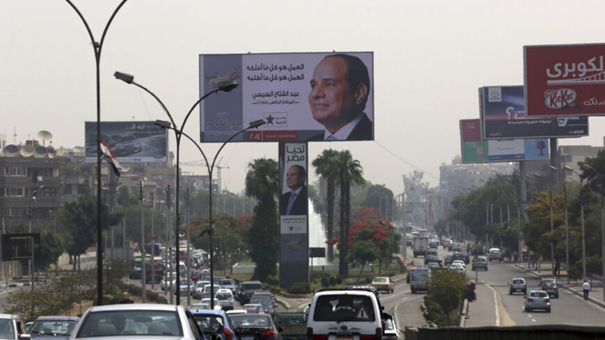 A huge electoral banner for presidential candidate and former army chief Abdel Fattah al-Sisi is seen among traffic during the third day of voting in the Egyptian presidential election in Cairo, May 28, 2014. Egyptians were initially slow to vote on a hastily added third day of a presidential election on Wednesday after lower-than-expected turnout threatened to damage the credibility of the man widely forecast to win, former army chief Abdel Fattah al-Sisi. REUTERS/Asmaa Waguih (EGYPT - Tags: POLITICS ELECT