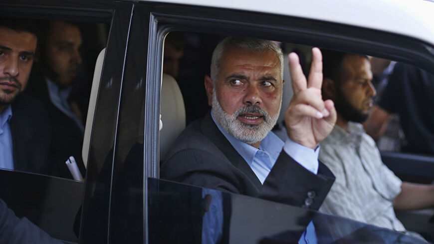 Senior Hamas leader Ismail Haniyeh gestures as leaves his office as a former Hamas government Prime Minister, in Gaza City June 2, 2014. President Mahmoud Abbas swore in a Palestinian unity government on Monday under a reconciliation deal with Hamas Islamists that led Israel to freeze U.S.-brokered peace talks with the Western-backed leader. REUTERS/Suhaib Salem  (GAZA - Tags: POLITICS) - RTR3RTWM