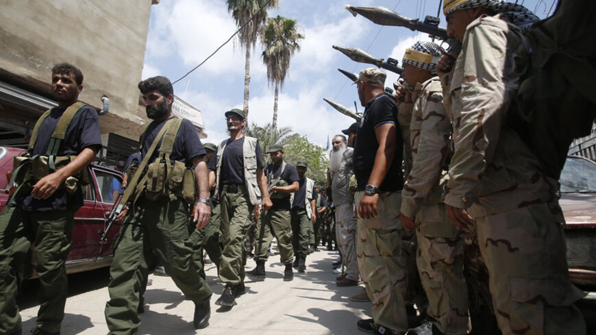 Palestinian gunmen from different factions walk as they hold their weapons during the launch of a joint security force that includes all Palestinian factions, to maintain stability at the Ain al-Hilweh Palestinian refugee camp near the port-city of Sidon, southern Lebanon July 8, 2014.
REUTERS/Ali Hashisho (LEBANON - Tags: POLITICS MILITARY) - RTR3XMT6
