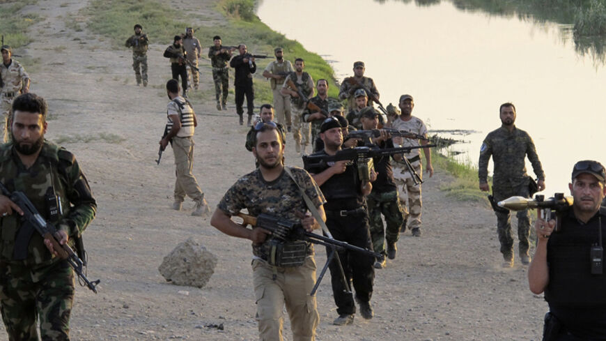 Armed Shi'ite volunteers from brigades loyal to radical cleric Muqtada al-Sadr walk during a patrol on the outskirts of Samarra August 2, 2014. Picture taken August 2, 2014. REUTERS/Stringer (IRAQ - Tags: CIVIL UNREST POLITICS MILITARY) - RTR414MN