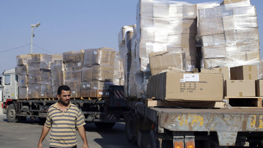 A Palestinian man walks next to a truck loaded with goods after entering Gaza at the Kerem Shalom crossing, in Rafah in the southern Gaza Strip August 28, 2014. An open-ended ceasefire in the Gaza war held on Wednesday as Israeli Prime Minister Benjamin Netanyahu faced strong criticism in Israel over a costly conflict with Palestinian militants in which no clear victor has emerged. The Egyptian-mediated ceasefire agreement that took effect on Tuesday evening, called for an indefinite halt to hostilities, th