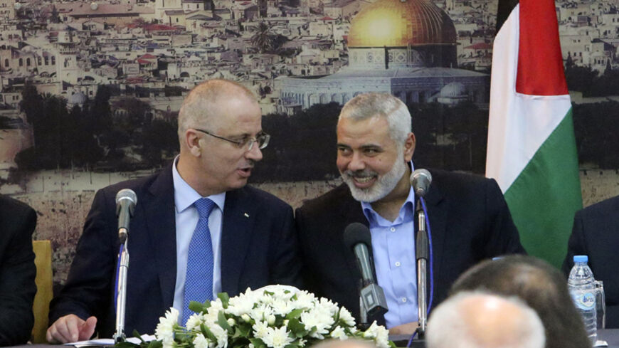 Senior Hamas leader Ismail Haniyeh (R) speaks with Palestinian Prime Minister Rami Hamdallah at Haniyeh's house in Gaza City October 9, 2014. Hamdallah arrived in the Hamas-dominated Gaza Strip on Thursday and convened the first meeting of a unity government there since a brief civil war in 2007 between Hamas and forces loyal to the Fatah party.     REUTERS/Ibraheem Abu Mustafa (GAZA - Tags: POLITICS CIVIL UNREST) - RTR49J4R