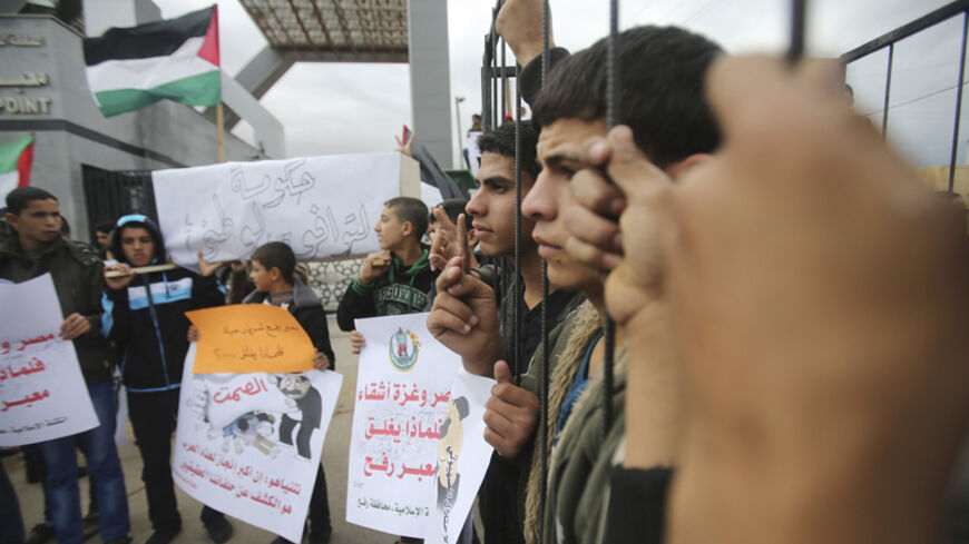 Palestinians stand behind the bars of a symbolic cage as they take part in a rally calling on Egyptian authorities to open the Rafah border crossing, at the crossing in the southern Gaza Strip November 23, 2014.  Egypt's decision to shut its border with the Gaza Strip has stranded thousands of Palestinians on the Egyptian side of the border while around a thousand people in Gaza are desperate to get out for medical treatment in Egypt, officials in Gaza say. Egypt closed Rafah, the only crossing point betwee