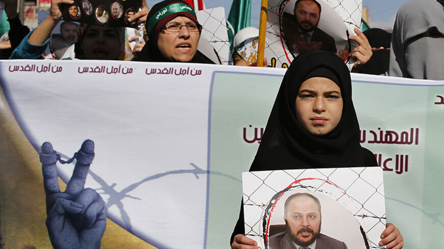 A protester from the Islamic Action Front, carries a picture of the deputy overall leader of Jordanian Muslim Brotherhood Zaki Bani Rsheid, who was arrested by the Jordanian authorities last week, after the Friday prayer in Amman November 28, 2014. Rsheid was arrested by the Jordanian authorities last week after he criticized the United Arab Emirates for issuing a list of Islamist organization it considered terrorist groups according to local media. REUTERS/Muhammad Hamed (JORDAN - Tags: POLITICS CIVIL UNRE