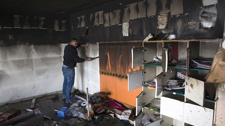A worker cleans up in a torched classroom in an Arab-Jewish school in Jerusalem November 30, 2014. Suspected Jewish extremists set fire to the classroom, police said on Sunday, targeting a symbol of co-existence in a city on edge over a recent surge in violence.
  REUTERS/Ronen Zvulun (JERUSALEM - Tags: POLITICS CIVIL UNREST EDUCATION) - RTR4G4B3