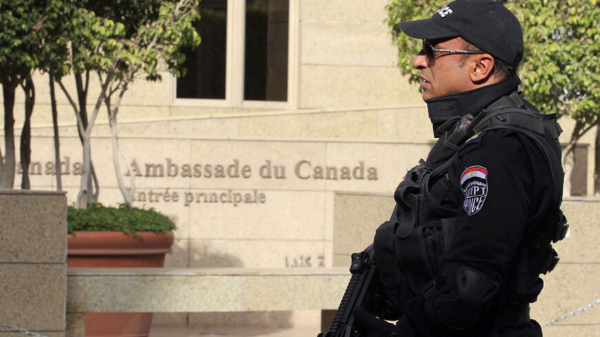 An armed police officer is deployed in front of the Canadian embassy in Cairo December 9, 2014. Canada's embassy in Cairo was closed on Monday until further notice because of security concerns, an official answering its emergency telephone line said, the second diplomatic mission to shut its doors this week.  REUTERS /Mohamed Abd El Ghany (EGYPT - Tags: POLITICS CIVIL UNREST) - RTR4H9SN