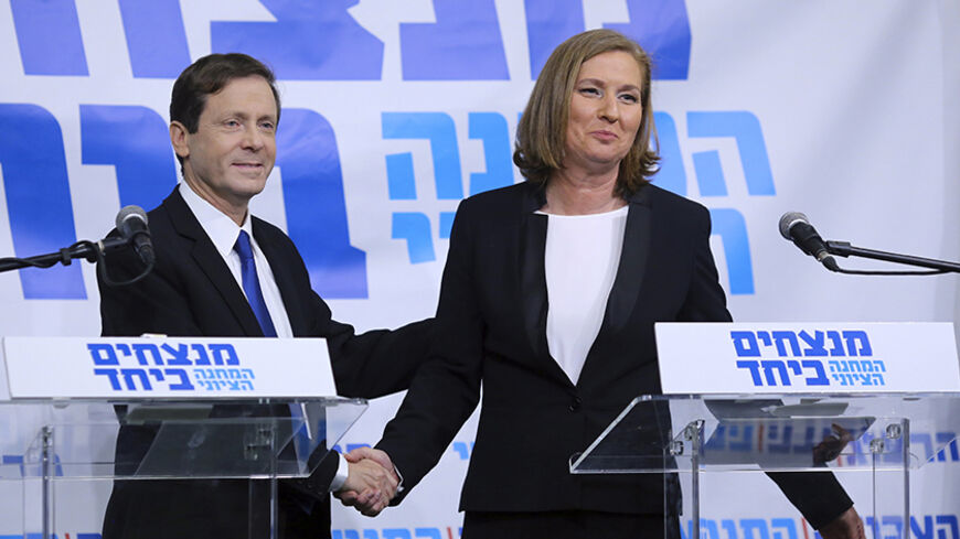 Issac Herzog (L), leader of Israel's Labour party, and former Israeli Justice Minister Tzipi Livni shake hands after their joint news conference in Tel Aviv December 10, 2014. Livni and the center-left parliamentary opposition leader formed a joint election ticket on Wednesday that polls show could pose a serious challenge to Prime Minister Benjamin Netanyahu in March.  REUTERS/Stringer (ISRAEL - Tags: POLITICS ELECTIONS) - RTR4HICW