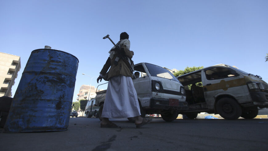 A Shi'ite Houthi rebel walks at a checkpoint in Sanaa December 11, 2014. The Houthis are an armed Shi'ite faction whose fighters had swept down from the north and stunningly captured Sanaa from the army about a month earlier. Their arrival following anti-government protests threatens to further destabilise Yemen, already wracked by political turmoil since the Arab Spring revolutions of 2011. To match Insight YEMEN-HOUTHIS/  REUTERS/Mohamed al-Sayaghi (YEMEN - Tags: CIVIL UNREST TRANSPORT) - RTR4HNFD