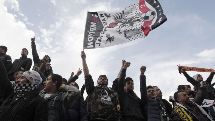 Protesters, who are supporting soccer fans on trial, shout slogans outside a court in Istanbul December 16, 2014. Thirty-five fans of Istanbul soccer club Besiktas go on trial accused of attempting to stage a coup during last summer's anti-government protests, in what rights groups say is a blatant abuse of criminal justice system and another sign of Erdogan's desire for revenge. Evidence cited against the fans supporting the idea they were engaged in criminal activity include them buying pizza and meatball