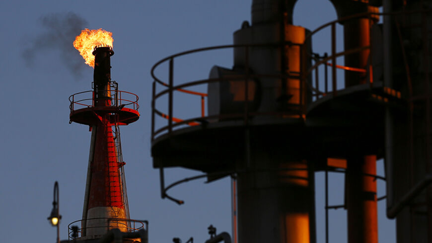 A flame shoots out of a chimney at a petro-industrial factory in Kawasaki near Tokyo December 18, 2014. Brent crude held steady above $61 a barrel on Thursday, bringing a sharp drop in prices to a temporary halt as companies are forced to cut upstream investments around the world. REUTERS/Thomas Peter (JAPAN - Tags: BUSINESS ENERGY) - RTR4II2W