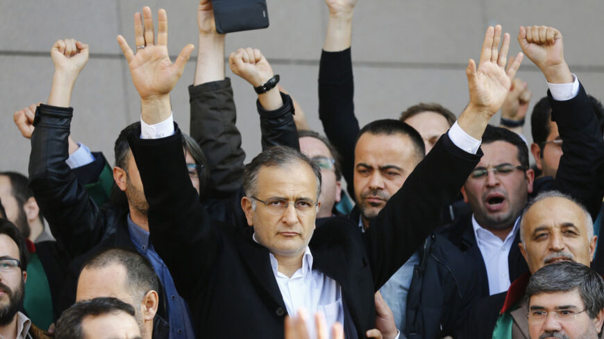 Zaman editor-in-chief Ekrem Dumanli greets his supporters after being released by the court outside the Justice Palace in Istanbul December 19, 2014. A Turkish court kept a media executive and three other people in custody on Friday pending trial on accusations of belonging to a terrorist group, in a case which President Tayyip Erdogan has defended as a response to "dirty operations" by his enemies. Hidayet Karaca heads Samanyolu Television which is close to the president's ally-turned foe Fethullah Gulen, 