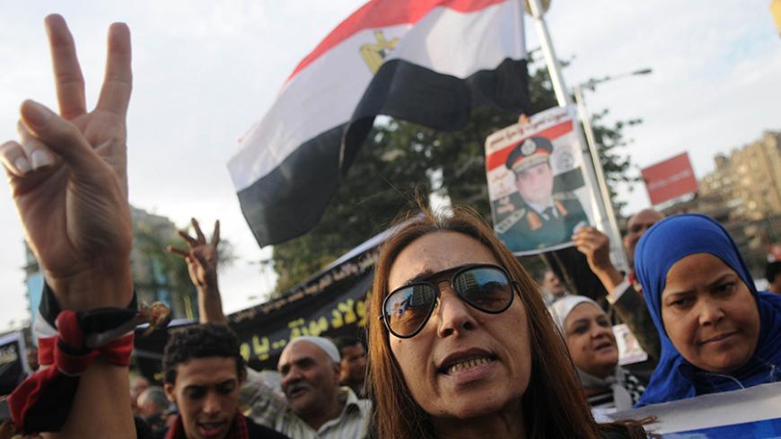 An Egyptian woman gestures during a protest against what they say is Qatar's backing of ousted Egyptian president Mohamed Mursi's government, outside the Qatari Embassy in Cairo November 30, 2013. REUTERS/Stringer (EGYPT - Tags: POLITICS CIVIL UNREST) - RTX15Z5S