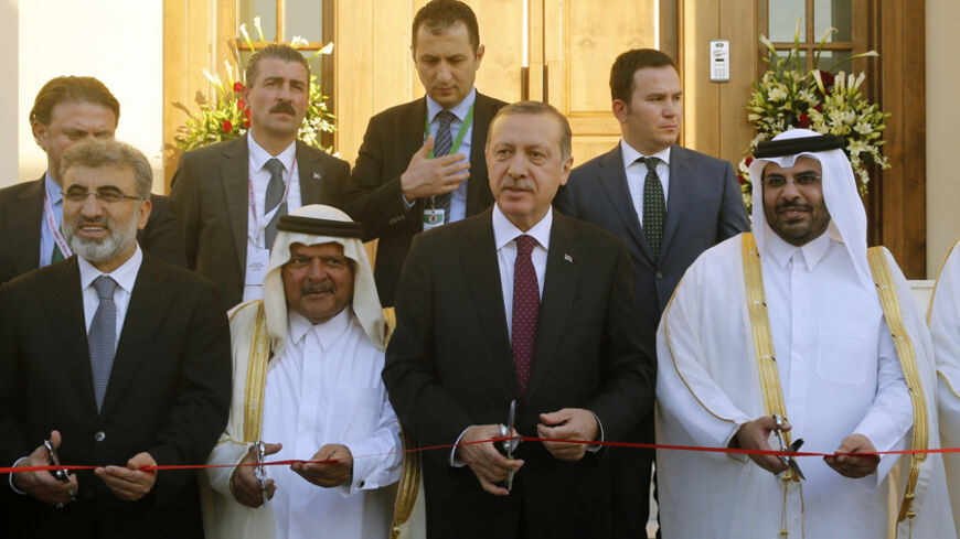 Turkey's Prime Minister Tayyip Erdogan (C) cuts the ribbon during the opening ceremony of the new building of the Turkish Embassy in Doha December 4, 2013.  REUTERS/Mohammed Dabbous (QATAR - Tags: POLITICS) - RTX163G5