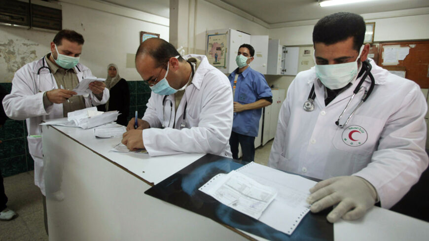 Palestinian doctors wear face masks at the reception of al-Shifa hospital in Gaza City December 6, 2009. H1N1 swine flu has finally reached the Gaza Strip, the health ministry said on Sunday, worrying Palestinians who had credited Israel's blockade of the territory with keeping the virus at bay. REUTERS/Mohammed Salem (GAZA POLITICS HEALTH) - RTXRJIC