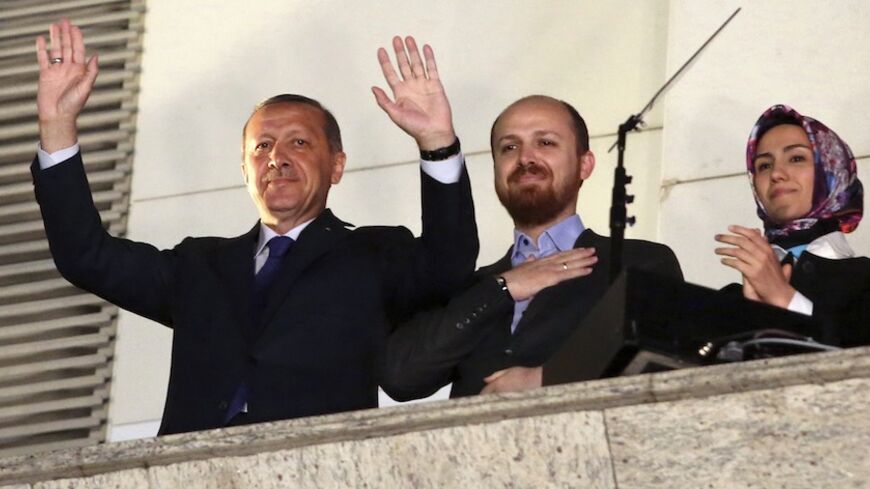 Turkish Prime Minister Tayyip Erdogan (L), accompanied by his son Bilal and daughter Sumeyye, greets his supporters at the AK Party headquarters in Ankara March 30, 2014. Tayyip Erdogan declared victory in local polls that had become a referendum on his rule and said he would "enter the lair" of enemies who have accused him of corruption and leaked state secrets. "They will pay for this," he said. Erdogan spoke from a balcony at his AK Party headquarters to thousands of cheering supporters as early results 