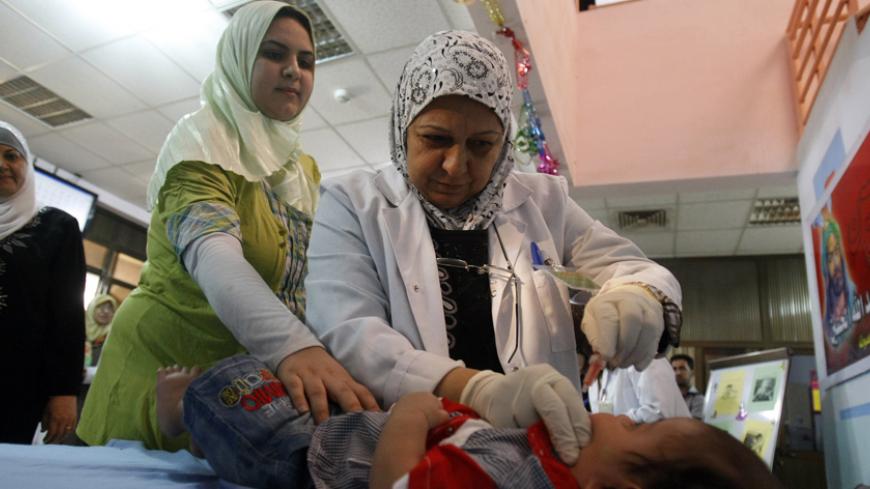 Nurses from a mobile team working for the Ministry of Health administer polio vaccinations to children under the age of five in a poor neighborhood of Baghdad on October 4, 2011. AFP PHOTO/SABAH ARAR (Photo credit should read SABAH ARAR/AFP/Getty Images)