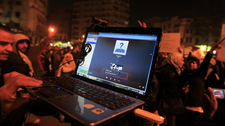 An Egyptian protester streams a demonstration via Skype as people gather in Cairo's Tahrir Square to denounce the military's attacks on women and to call for an immediate end to the violence against protesters on December 20, 2011. AFP PHOTO/MOHAMMED ABED        (Photo credit should read MOHAMMED ABED/AFP/Getty Images)