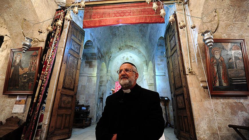 TO GO WITH AFP STORY BY PHILIPPE ALFROY
Priest Gabriel Aktas poses in Kirklar, a Syriac church in Mardin, south-eastern Turkey, on November 17, 2014. The Christian Assyrian community in Turkey, which now numbers no more than a several thousand, has been hit by wave after wave of immigration even since the foundation the modern Turkish state in 1923 out of the ruins of the multi-ethnic Ottoman Empire. But hope has not been lost that a future presence can be continued and memory of the past retained, with som
