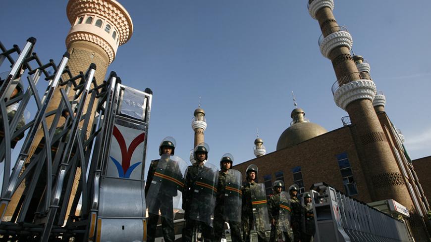 Chinese paramilitary police in riot gear guard the entrance of the Dong Kuruk Bridge mosque in the centre of the city of Urumqi in China's Xinjiang Autonomous Region July 10, 2009. The passionate anger of the weekend riots, that killed around 150 people, gave way to cold bitterness on both sides of the ethnic divide in China's strife-torn Muslim region of Xinjiang on Thursday, and was likely to last long after the troops go.     REUTERS/David Gray     (CHINA CONFLICT MILITARY POLITICS IMAGES OF THE DAY) - R