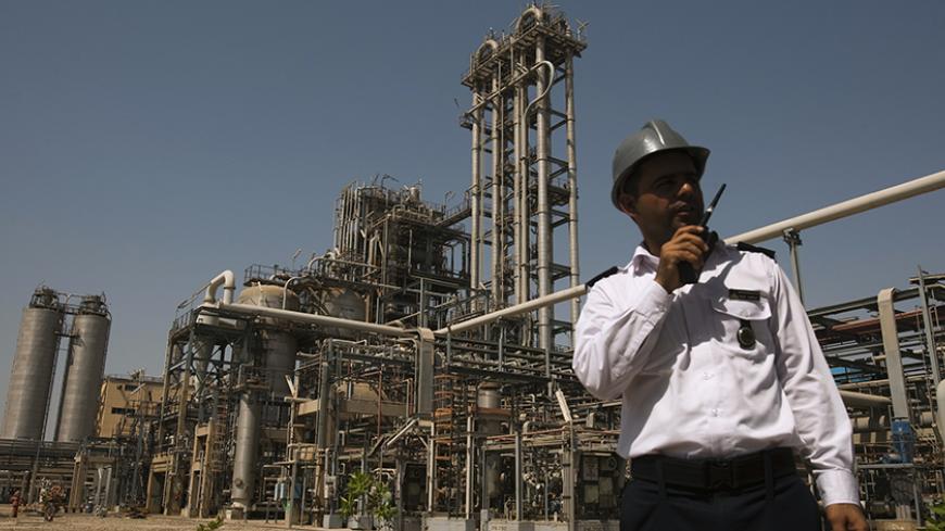 A security personnel stands in front of the Mahshahr petrochemical plant in Khuzestan province,1032 km (641 miles) southwest of Tehran, September 28, 2011. REUTERS/Raheb Homavandi  (IRAN - Tags: BUSINESS ENERGY INDUSTRIAL) - RTR2RYWC
