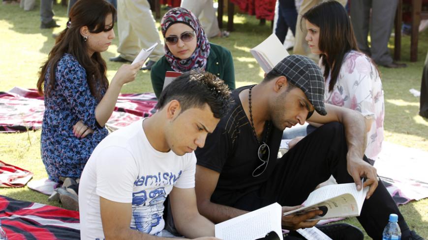People read books during the launch of a reading initiative in Baghdad September 29, 2012. The "I am Iraqi... I read" initiative was launched by activists on Saturday in Baghdad to encourage Iraqis to read in a country that had suffered decades of war and internal struggle. Picture taken September 29, 2012. REUTERS/Thaier al-Sudani (IRAQ - Tags: SOCIETY EDUCATION) - RTR38M7Q