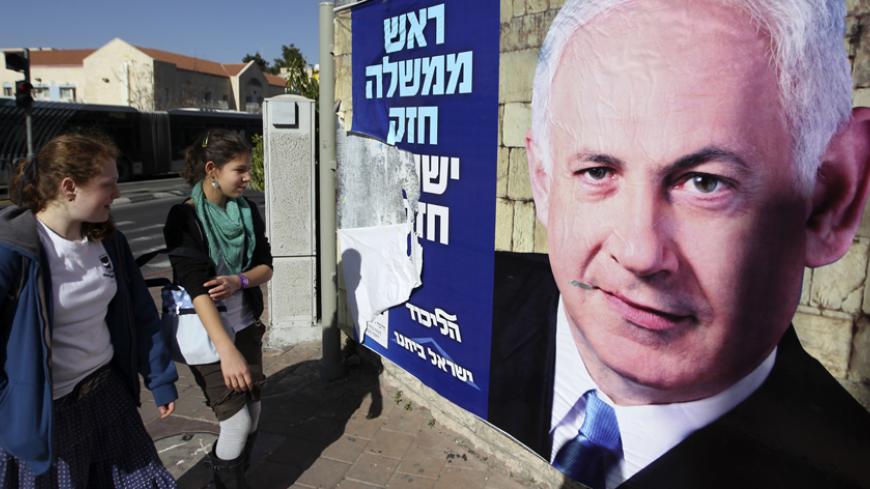 Youths look at a Likud-Yisrael Beitenu campaign poster depicting Israel's Prime Minister Benjamin Netanyahu in Jerusalem January 17, 2013. Netanyahu looks set to form a new governing coalition after next week's election, polls show, with the only question being whether he wants to soften its hardline contours. REUTERS/Ammar Awad (JERUSALEM - Tags: POLITICS ELECTIONS) - RTR3CKHF
