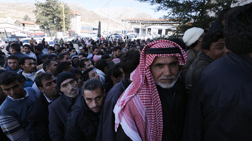 Syrians stand in a queue to get a visa stamp to enter Lebanon town during their arrival at the Lebanese Masna'a border point in eastern Bekaa, January 22, 2013. REUTERS/Jamal Saidi    (LEBANON - Tags: POLITICS CIVIL UNREST) - RTR3CSS0