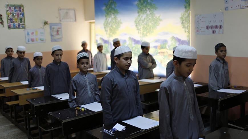 Iraqi Shi'ite students attend classes at an Islamic school in Sadr City in Baghdad May 5, 2014. Iraq is now gripped by its worst violence since the heights of its 2005-2008 sectarian war, and Sunni Islamist insurgents who target Shi'ites have been regaining ground in the country over the past year. But despite the instability, daily life continues in poor Shi'ite neighbourhoods of Baghdad such as Al-Fdhiliya and Sadr City - a sprawling slum marred by poor infrastructure and overcrowding.  REUTERS/Ahmed Jada