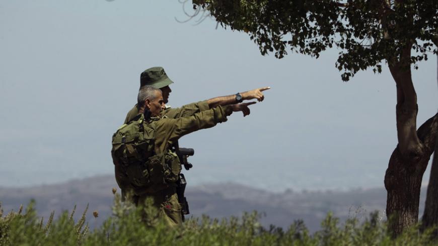 Israeli soldiers observe the Syrian side of the Quneitra border crossing between the Israeli-controlled Golan Heights and Syria, August 29, 2014. U.N. officials shuttled along the rocky frontier between Syria and the Israeli-occupied Golan Heights on Friday, trying to establish the whereabouts of 44 United Nations peacekeepers seized by al-Qaeda-linked militants inside Syria. Israeli forces took up positions at Quneitra, a fortified crossing between Syria and the Golan, barely 400 meters (437 yards) from Nu