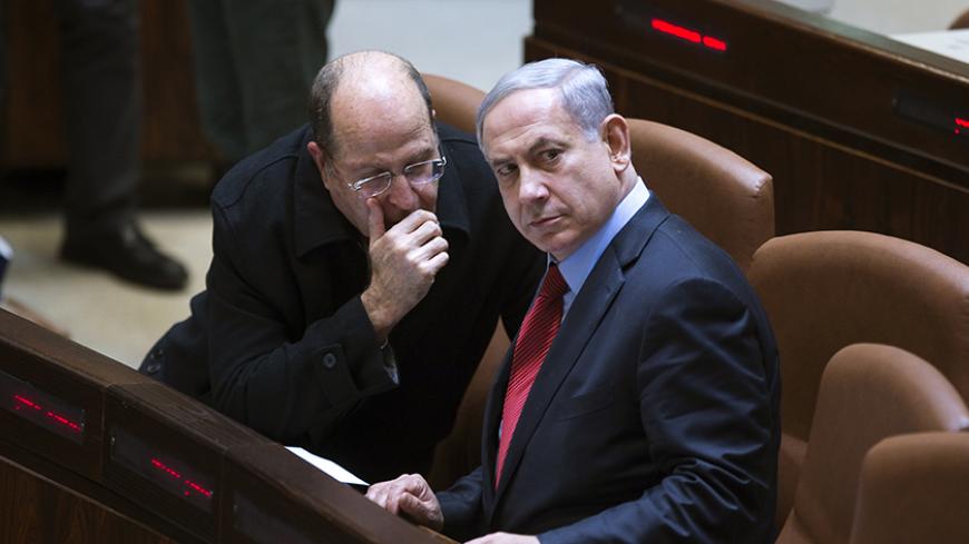 Israel's Defence Minister Moshe Yaalon (L) speaks with Prime Minister Benjamin Netanyahu during a session of the Knesset, the Israeli parliament, in Jerusalem December 1, 2014. Netanyahu, enmeshed in a cabinet crisis, said on Monday he would call an early national election unless rebellious ministers stopped attacking government policies. REUTERS/Ronen Zvulun (JERUSALEM - Tags: POLITICS MILITARY) - RTR4GAPY