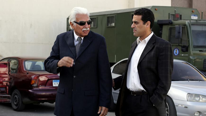 Former Egyptian Prime Minister Ahmed Nazif (L) walks with his son outside of a court after his trial was delayed, in the outskirts of Cairo, December 29, 2014. Nazif is facing a retrial as he was convicted of a corruption case for which he had been held since the revolution that toppled Hosni Mubarak. REUTERS/Asmaa Waguih (EGYPT - Tags: POLITICS CRIME LAW) - RTR4JJQM