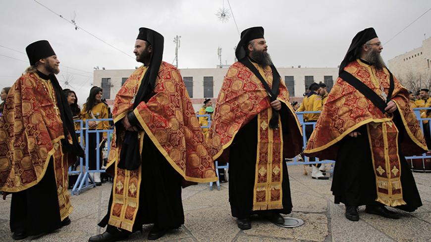 Members of the Greek Orthodox clergy wait for the arrival of the Greek Patriarch of Jerusalem Metropolitan Theophilos before the Eastern Orthodox Christmas procession outside the Church of the Nativity in the West Bank town of Bethlehem January 6, 2015. REUTERS/Ammar Awad (WEST BANK - Tags: RELIGION SOCIETY TPX IMAGES OF THE DAY) - RTR4K85Z