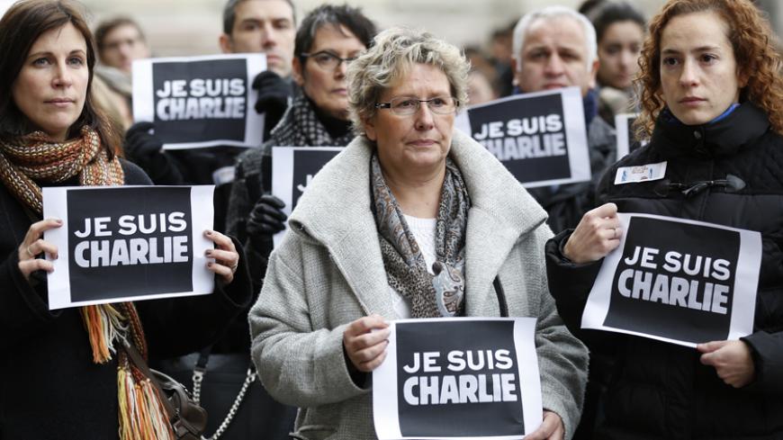 People holds placards which read "I am Charlie" during a minute of silence in Strasbourg January 8, 2015 for victims of the shooting at the Paris offices of weekly satirical newspaper Charlie Hebdo on Wednesday. French police extended a manhunt on Thursday for two brothers suspected of killing 12 people at a satirical magazine in Paris in a presumed Islamist militant strike that national leaders and allied states described as an assault on democracy. France began a day of mourning for the journalists and po