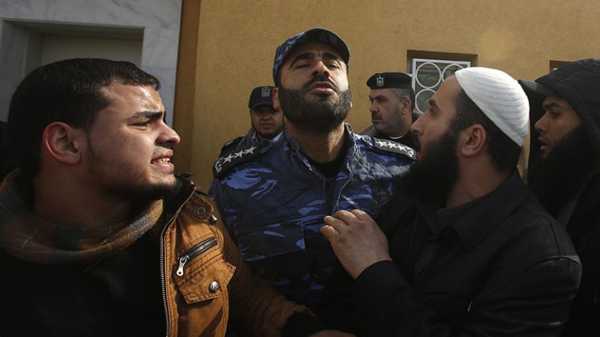 A Palestinian police officer loyal to Hamas pushes back Salafists during a protest against satirical French weekly magazine Charlie Hebdo's cartoons of the Prophet Mohammad, outside the French Cultural Centre in Gaza city January 19, 2015. Dozens of Jihadist Salafi men rallied in Gaza on Monday to condemn continued publication by French satirical magazine Charlie Hebdo of cartoons deemed offensive to Islam's Prophet. Charlie Hebdo published a picture of Mohammad weeping on its cover last week after gunmen s