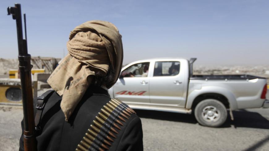 A Houthi fighter mans a checkpoint on a road leading to the U.S embassy in Sanaa January 21, 2015. Yemen's minority Shi'ite Houthi fighters took up guard at President Abd-Rabbu Mansour Hadi's home on Wednesday but said they had not toppled him, after two days of fighting which left little doubt that the enfeebled leader was now at their mercy. REUTERS/Mohamed al-Sayaghi (YEMEN - Tags: CIVIL UNREST POLITICS) - RTR4MBMY