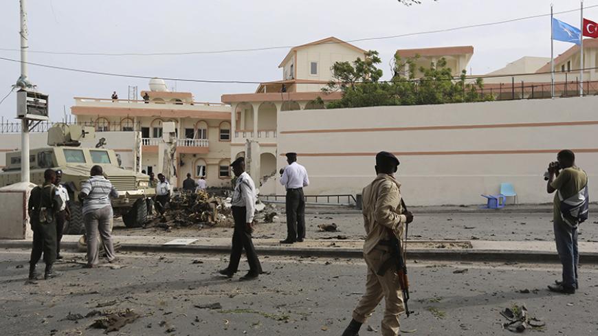 Somali government soldiers and African Union Mission in Somalia (AMISOM) peacekeepers secure the scene of a suicide car explosion in front of the SYL hotel in the capital Mogadishu January 22, 2015. The Somali Islamist group al Shabaab claimed responsibility for a bomb attack at the gate of the hotel where Turkish delegates were meeting on Thursday, a day ahead of a visit by their president, Tayyip Erdogan, to the Somali capital. REUTERS/Feisal Omar (SOMALIA - Tags: CIVIL UNREST POLITICS CRIME LAW MILITARY)