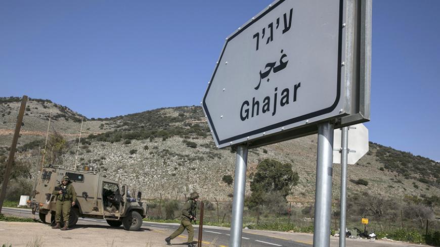 Israeli soldiers are seen next to a sign post pointing to the village of Ghajar near Israel's border with Lebanon January 28, 2015. A Hezbollah missile strike wounded four Israeli soldiers on Wednesday, the biggest attack on Israeli forces by the Lebanese guerrilla group since a 34-day war in 2006. Israeli artillery fired at least 22 shells into open farmland in southern Lebanon after the strike, a Lebanese security source said, and thick smoke rose over the area. REUTERS/Baz Ratner (ISRAEL - Tags: MILITARY