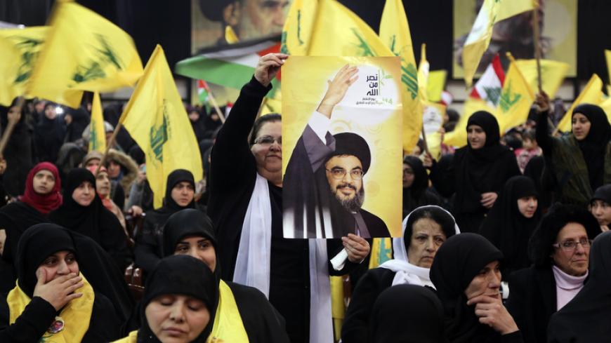A supporter of Lebanon's Hezbollah leader Sayyed Hassan Nasrallah holds up a poster of him as he appears on a screen to speak at an event to commemorate the deaths of six Hezbollah fighters and an Iranian general killed by an Israeli air strike in Syria on January 18, in Beirut's southern suburbs, January 30, 2015. Nasrallah said on Friday his group did not want war with Israel but was ready for one and had the right to respond to Israeli "aggression" in any time and place. The words on the woman's hand rea
