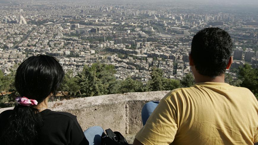 A Syrian couple sit at Mount Qasioun in Damascus September 12, 2005. Syria agreed on Monday with chief U.N. investigator Detlev Mehlis on the procedures for questioning Syrian witnesses in the probe into the killing of former Lebanese Prime Minister Rafik al-Hariri. REUTERS/Jamal Saidi  JS/TY - RTRNNQ1