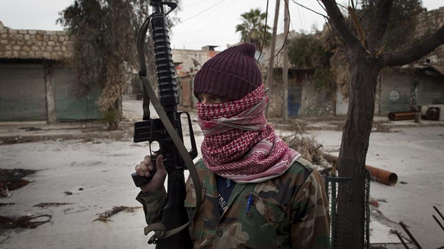TO GO WITH AFP STORY BY ANTONIO PAMPLIEGA
A masked Syrian Turkmen rebel takes posision in the Hanano district of the northern city of Aleppo on January 28, 2013. Members of Syria's Turkmen minority have joined forces with rebels fighting President Bashar al-Assad's regime in a struggle they say is for democracy and revenge for years of oppression. AFP PHOTO/JM LOPEZ        (Photo credit should read JM LOPEZ/AFP/Getty Images)
