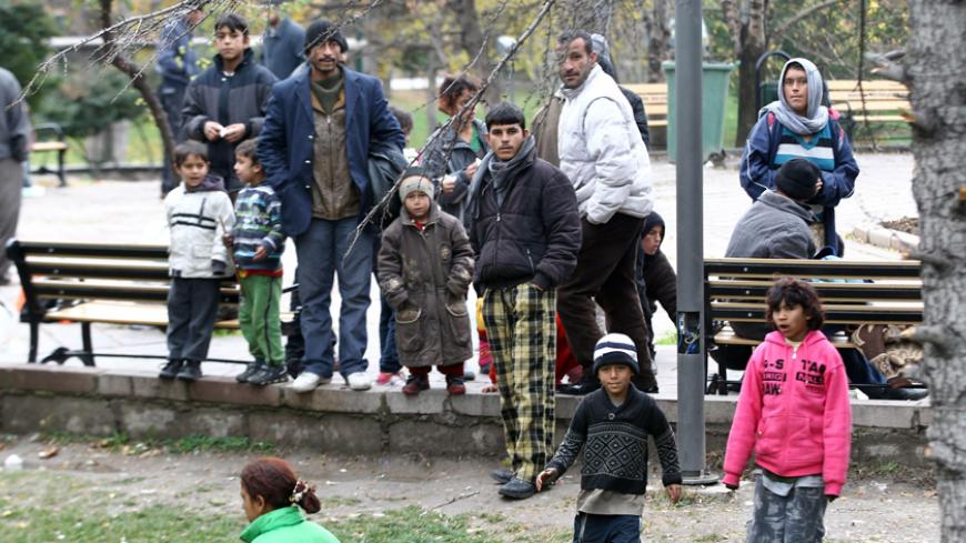 Syrian refugees who live in the streets stand in a public garden in central Ankara on November 23, 2014. There are about 2 million Syrian refugees who fled the civil war in their country living in Turkey . AFP PHOTO/ADEM ALTAN        (Photo credit should read ADEM ALTAN/AFP/Getty Images)