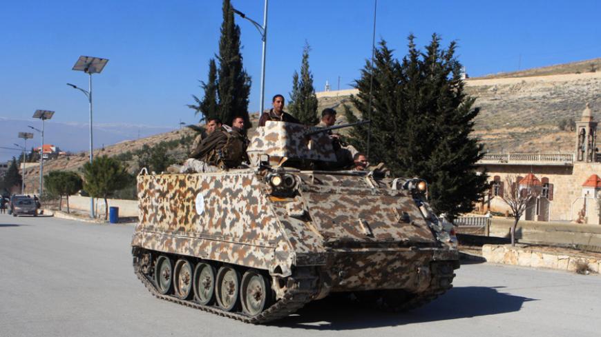 Lebanese army troops drive an armoured personnel carrier (APC) in the village of Ras Baalbak in the eastern Bekaa Valley near the border with Syria during clashes between Islamist fighters and Lebanese troops on Jananuary 23, 2015, leaving casualties on both sides. Gunmen launched a large-scale attack on an army outpost close to Ras Baalbek, near Lebanon's eastern frontier with Syria, an area that has seen regular incursions from militants fighting in Syria's war. AFP PHOTO / STR        (Photo credit should